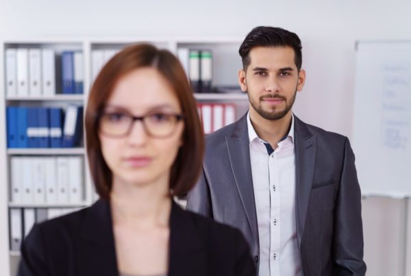 Calm businessman behind woman in office