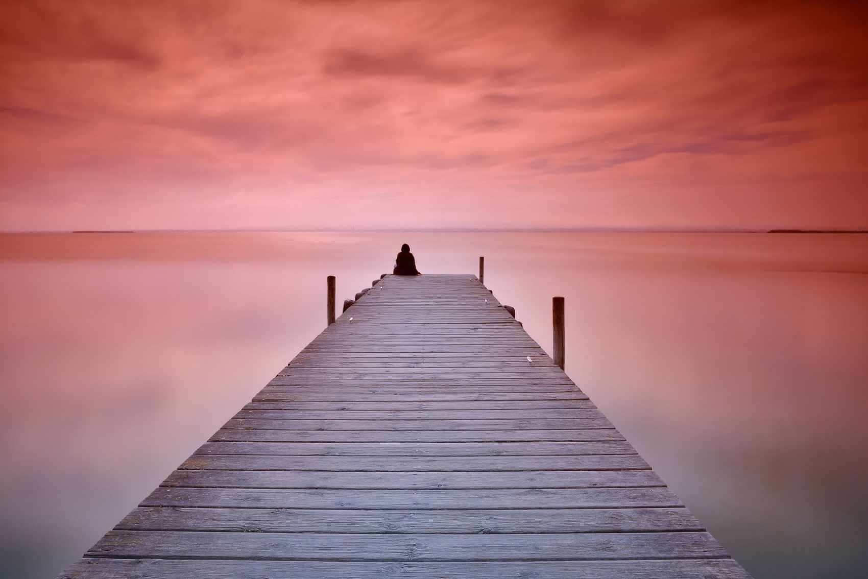 Lonely person sitting on pier